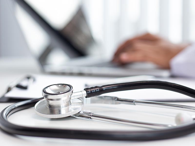 Doctor uses a laptop computer to record patient information and